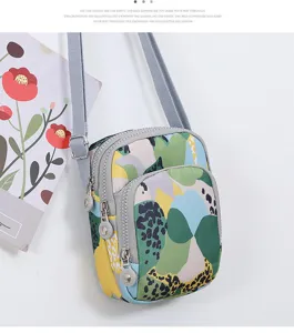 Détail de mini sac bandoulière vertical en nylon avec poches multiples à fermeture éclair.