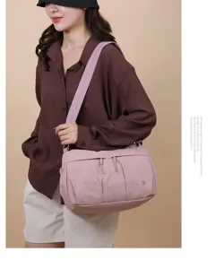 Vue détaillée du sac à bandoulière en nylon élégant avec plusieurs poches et design décontracté.