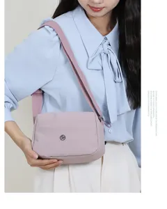 Lichte nylon schoudertas voor dames, stijlvolle crossbody tas met meerdere lagen zachtroze.