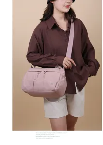 Sac bandoulière rose en nylon élégant avec plusieurs poches, léger et spacieux pour les voyages.