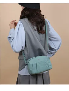 Sac à bandoulière en nylon détail montrant un design minimaliste, sangle réglable.