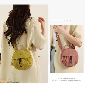 Vue détaillée du sac bandoulière rond en nylon avec poignée, présentant plusieurs couleurs.