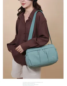 Détail de sac bandoulière en nylon avec poches multiples, sangle large et design léger.