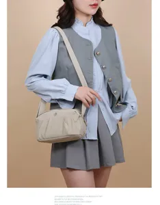 Vue detaillee du sac bandouliere en nylon avec poche avant plaissee et sangle large et confortable.