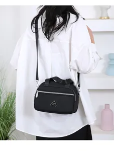 Sac bandoulière polyvalent en nylon noir pour femme avec poignées et bandoulière réglable.