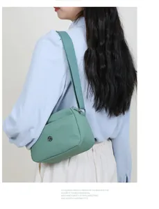 Gedetailleerd overzicht van de lichtgroene nylon schoudertas met verstelbare riem en metalen.