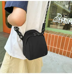 Compacte zwarte crossbody egg bag met meerdere vakken en verstelbaar schouderriem detail.