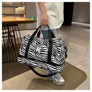 Vista detallada de la bolsa de viaje con estampado de cebra, con doble compartimento y asas.