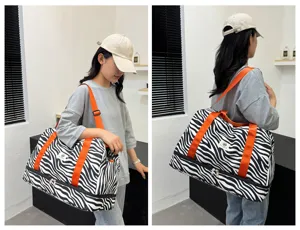 Bolso de viaje grande con estampado de cebra, correas naranjas y compartimento.