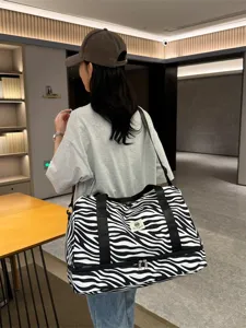 Bolso de viaje con estampado de cebra de gran capacidad y compartimento inferior.