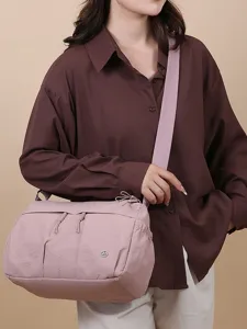 Sac bandoulière léger en nylon avec plusieurs poches et sangle pour le voyage.