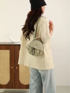 Sac bandoulière rond minimaliste élégant pour femme, sac à main décontracté en nylon.