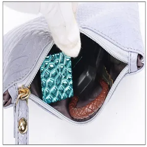 Paarse krokodillenpatroon clutch tas detail met interne opbergruimte en rits.