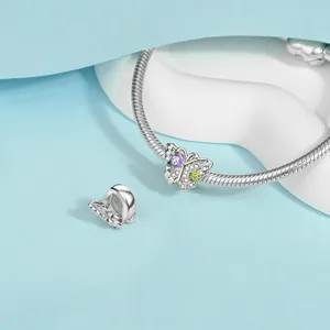 Close-up detail of silver snake chain bracelet with sparkling butterfly charm accessory.