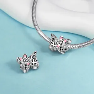 Close-up detail of silver butterfly charm bead with pink enamel and sparkling zirconia crystals.