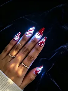 Close-up detail van kerst neppe nagels met gloeiende sneeuwvlokken en strepen ontwerp.