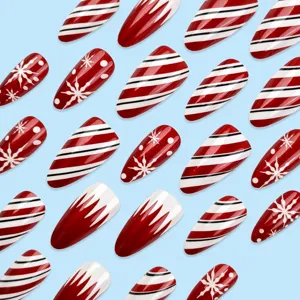Detailopname van kerst-neppnagels met rood-witte zuurstokstrepen en schattige sneeuwvlokmotieven.