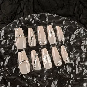 Close up of long coffin press on nails featuring nude base with silver butterfly and rhinestones.