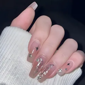 Uñas postizas largas y cuadradas con degradado nude, mariposas plateadas y brillantes estrás.