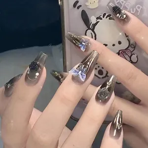 Uñas postizas degradadas oscuras con dijes 3D de mariposa y rosa, vista detallada elegante.