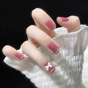 Uñas postizas hechas a mano en rosa con punta francesa blanca y lazo 3D elegante.