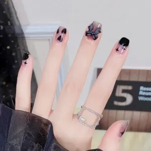 Uñas postizas hechas a mano con lazos negros 3D y estrellas brillantes para un estilo elegante.