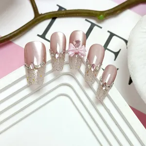 Uñas postizas hechas a mano largas con efecto ojo de gato rosa, brillo y lazo 3D.