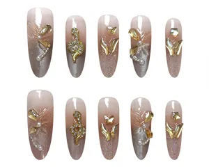 Detalles de uñas postizas con degradado cat-eye, serpiente dorada y brillantes pedrería.