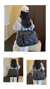 Detailed view of the black and white polka dot travel duffel bag worn by a model in action.