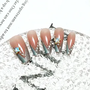 Vista detallada de uñas postizas hechas a mano con ojo de gato y estrellas de cristal