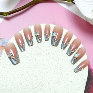 Detalle de uñas postizas hechas a mano, forma bailarina con ojo de gato, estrás y estrella.