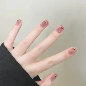 Uñas postizas artesanales con cerezas rojas y pedrería brillante sobre base efecto ojo de gato.