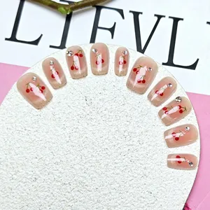 Uñas postizas hechas a mano con diseño de cerezas rojas, gel ojo de gato rosa y pedrería brillante.