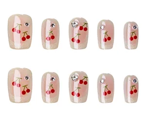 Uñas postizas hechas a mano con diseño de cerezas, pedrería brillante y efecto ojo de gato.
