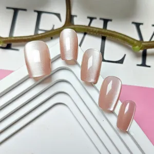 Primer plano detallado de uñas postizas nude rosa con brillante efecto ojo de gato.