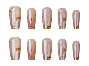 Detalle de uñas postizas largas con brillo ojo de gato y lazos dorados en 3D.