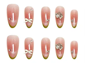 Uñas postizas hechas a mano con diseño de ojo de gato verde y lazo de estrás para manicura.