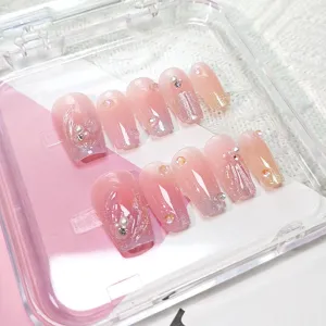 Primer plano detallado de uñas postizas hechas a mano con brillo ojo de gato, detalles 3D y estrás.