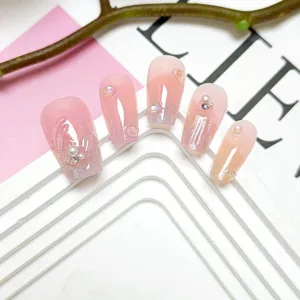 Uñas postizas de ojo de gato hechas a mano con perlas 3D, detalle de nail art rosa degradado.