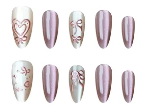 Detailed view of handmade almond press-on nails with cat eye, heart and bow designs.