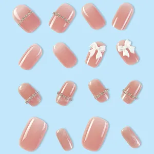 Unghie finte effetto occhio di gatto rosa nude con strass di cristallo e fiocco 3D.