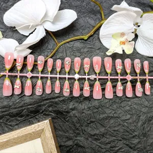 Primo piano dettagliato di unghie finte francesi verdi con glitter e strass con fiocco.
