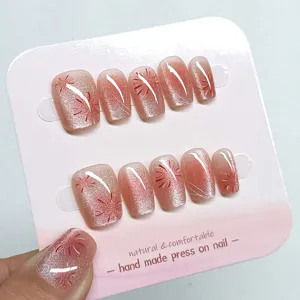 Detalle de uñas postizas hechas a mano con efecto ojo de gato, set rosa brillante elegante.