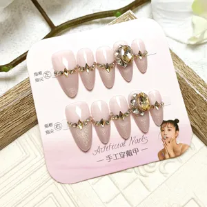 Handmade press-on nails with nude pink cat-eye glitter and large crystal rhinestone decor.