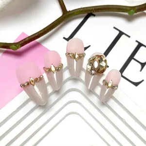 Handmade nude pink press-on nails with cat-eye glitter and large rhinestones detail.