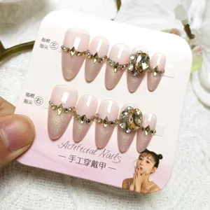 Stunning nude pink press-on nails featuring cat-eye glitter and large luxury rhinestones.