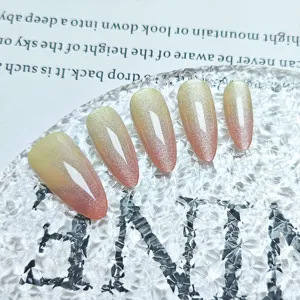Primo piano dettagliato di unghie finte fatte a mano con sfumatura occhio di gatto rosa e giallo.