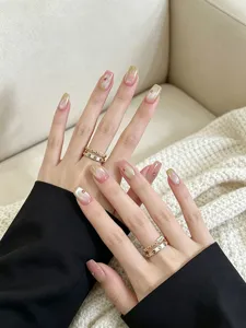 Gros plan détaillé de faux ongles effet cat-eye dégradé avec strass brillants.