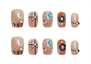 Vista detallada de uñas postizas cortas con diseño de cuadros, lazos y bonitos donuts.
