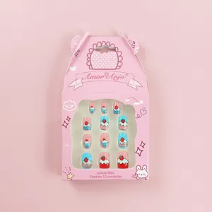 Primer plano detallado de uñas postizas lindas para niños con diseños de pasteles y fresas.
